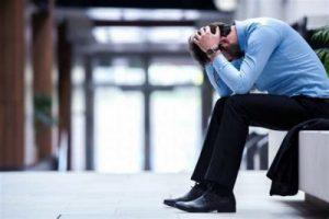 Man feeling burned out, holding his head in his hands